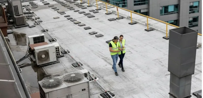 a pair of workers inspecting the roof. roof leaks